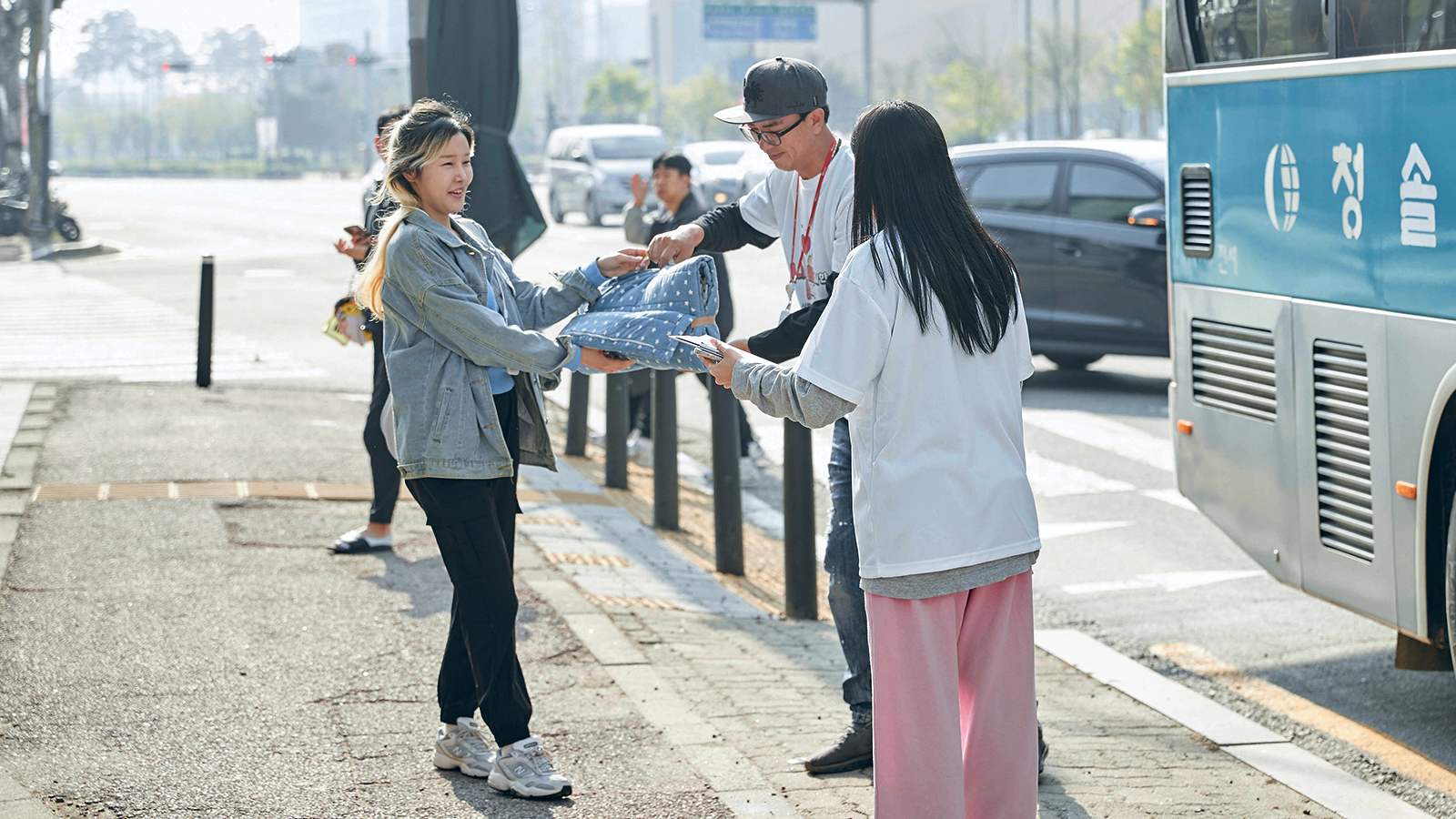 SK하이닉스 구성원들이 비글구조네트워크 보은쉼터에 기부할 침구류를 손에 들고 청주 캠퍼스 앞 출발지에 모였다.